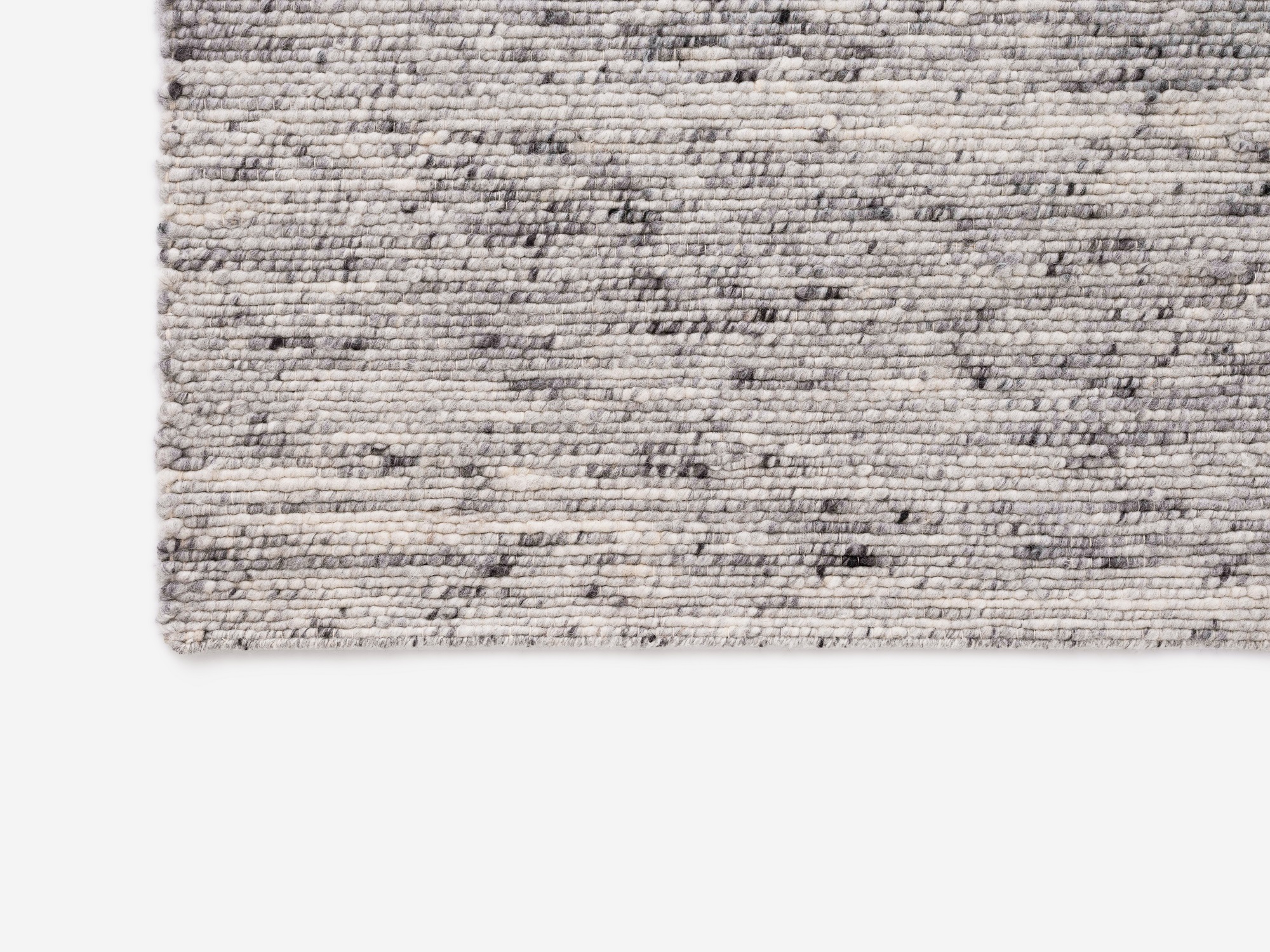 Corner view of light grey living room rug